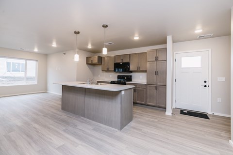 A kitchen with a large island and wooden floors.