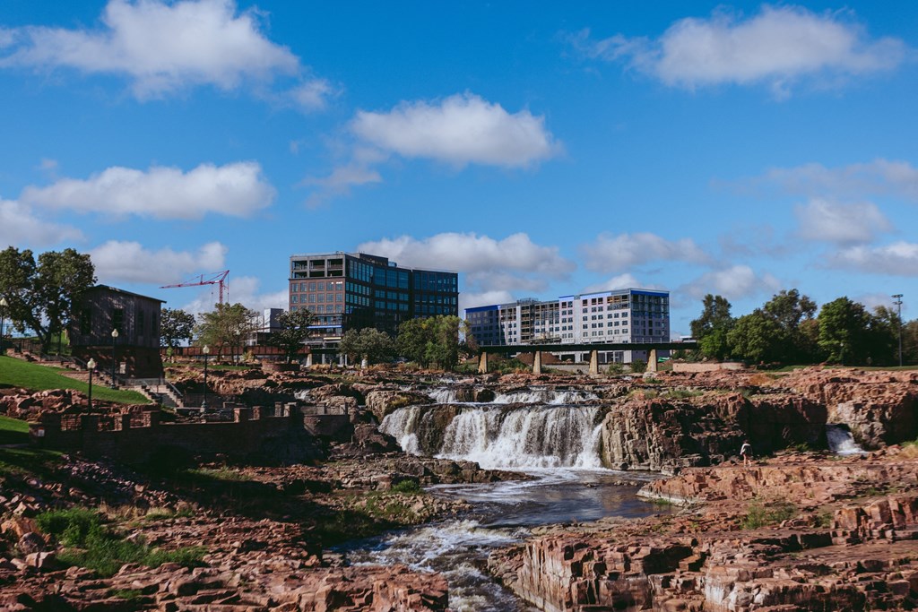 a waterfall in a river with a city in the background
