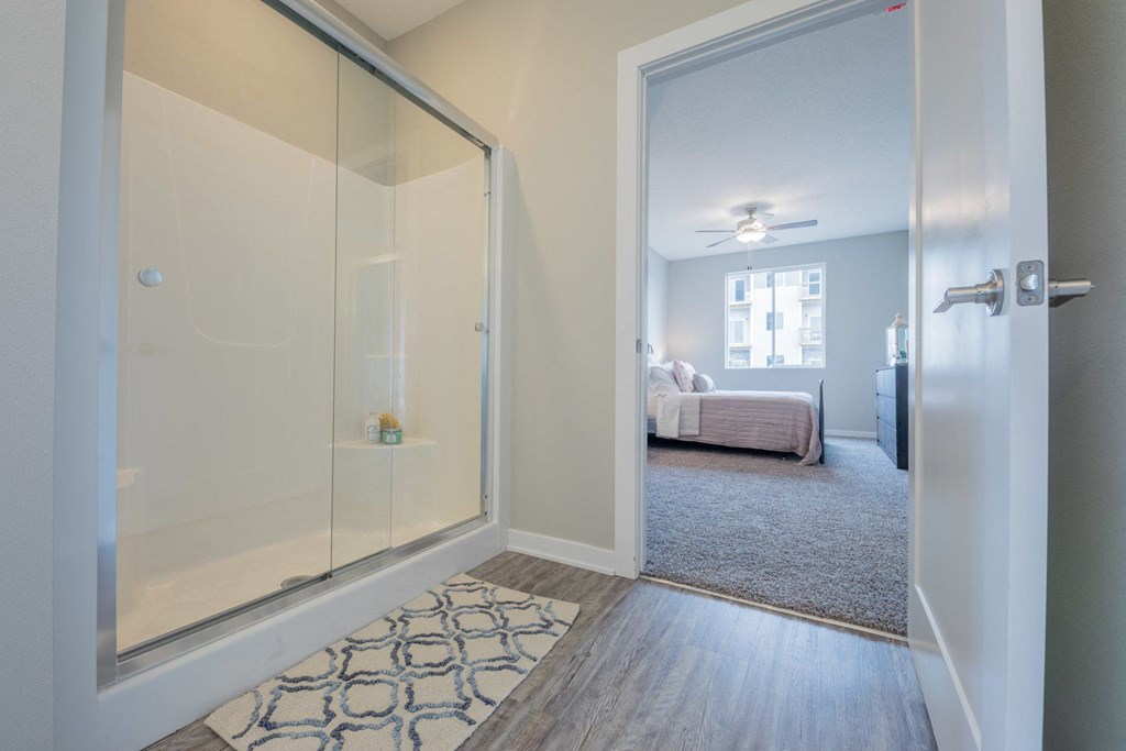 a glass door opens into a bedroom with a bed and a closet