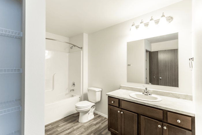 a bathroom with a toilet sink and shower and a mirror