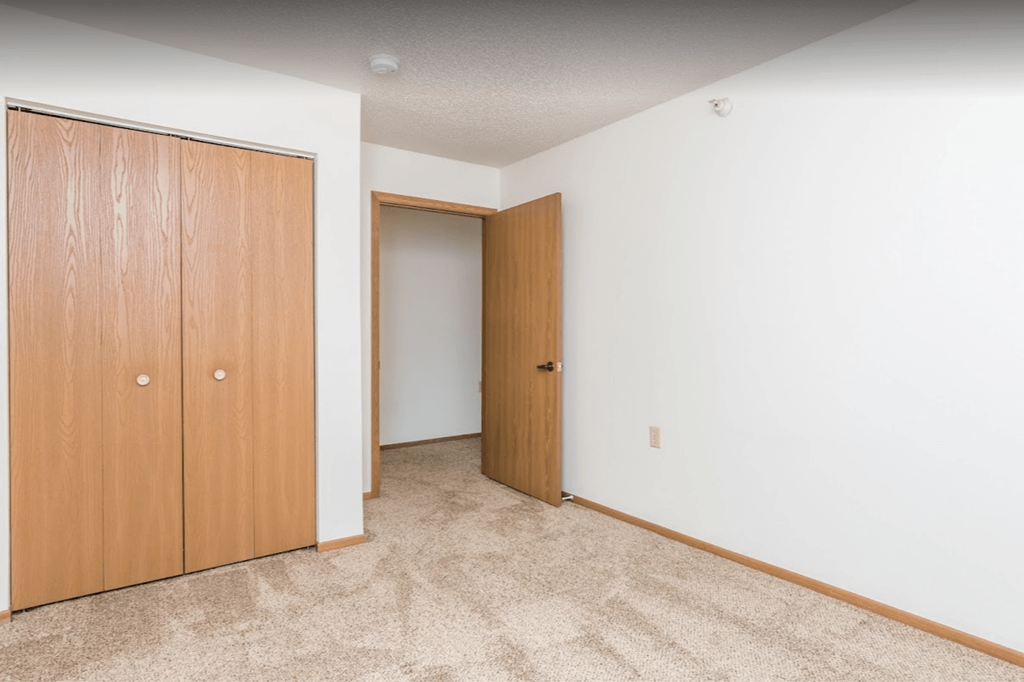 a bedroom with a closet and a door to a hallway