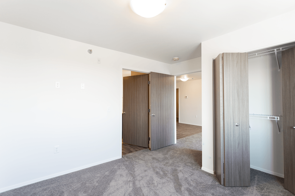 a bedroom with a closet and a door to a hallway