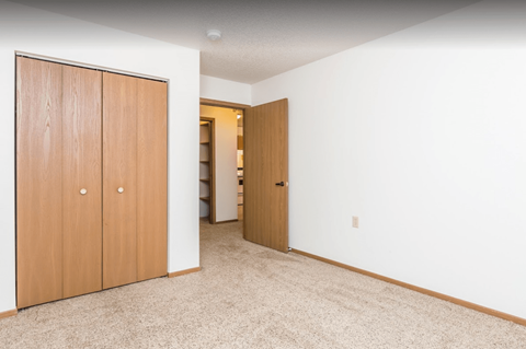 a bedroom with a closet and a door to a bathroom