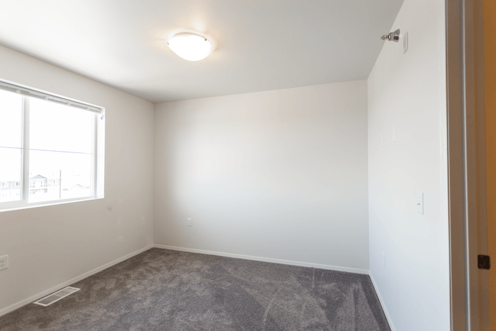 an empty room with carpet and a window