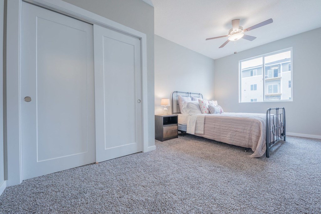 a bedroom with a bed and a ceiling fan