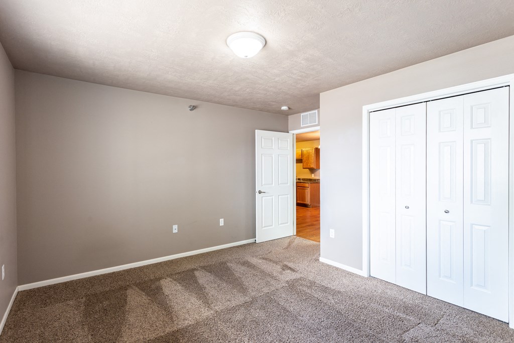 an empty room with white doors and a carpeted floor
