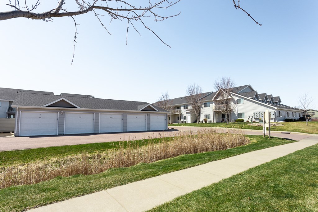 a row of houses with blue garage doors and a sidewalk