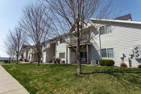 the residences at the crossings apartments exterior of the building with lawn and trees