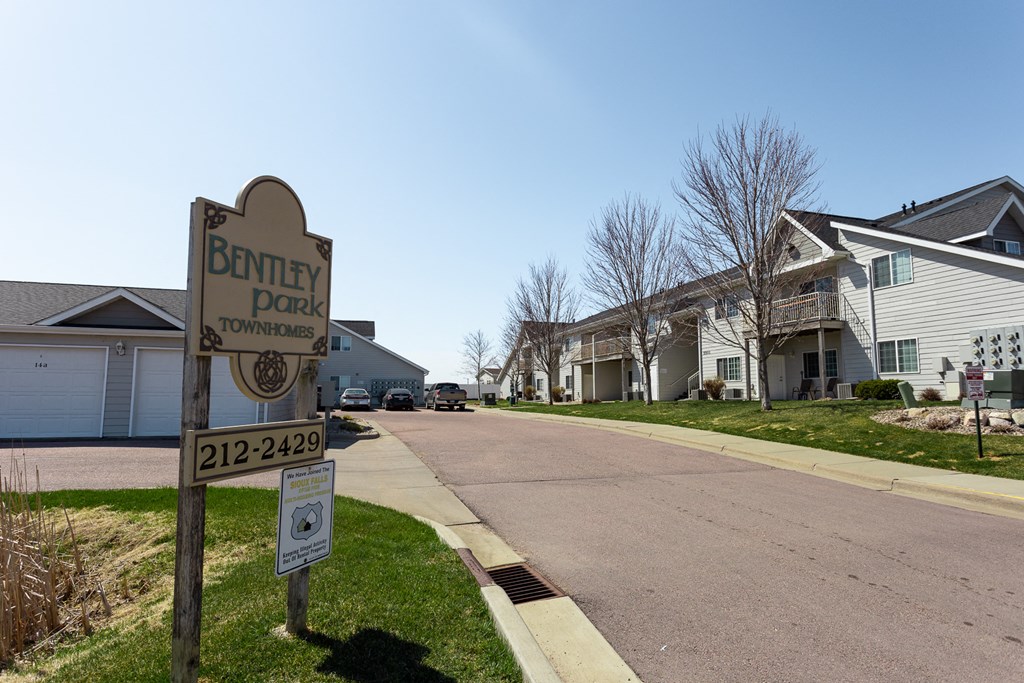 a street with houses and a sign on the side of the road