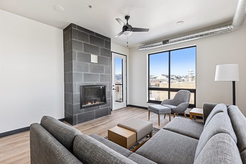 A living room with a grey couch and a fireplace.