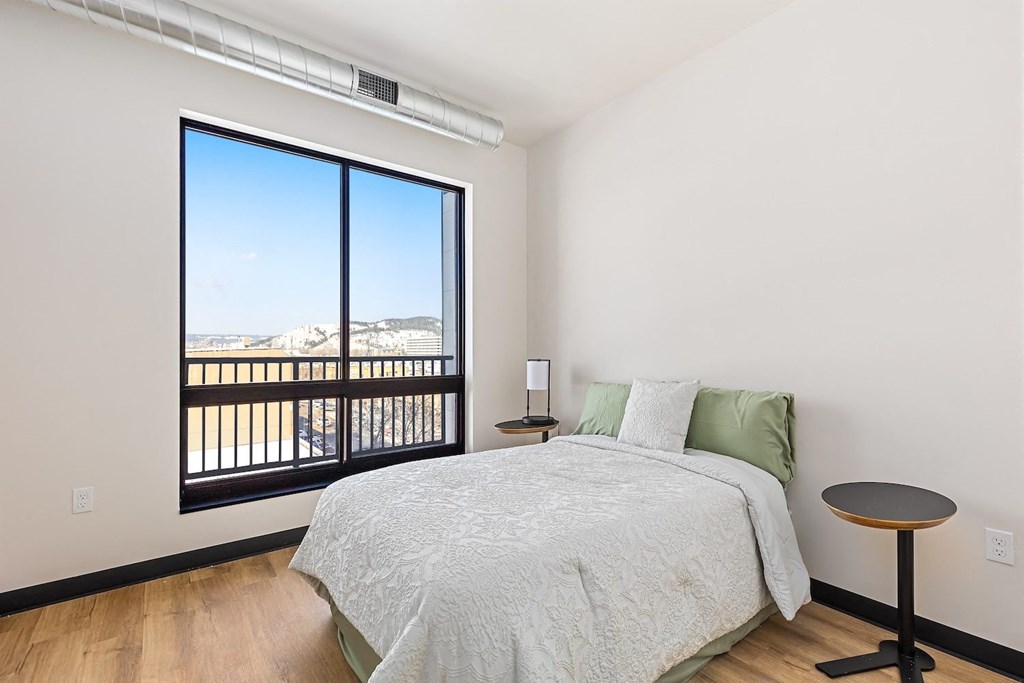 A bedroom with a large bed and a view of the mountains outside.