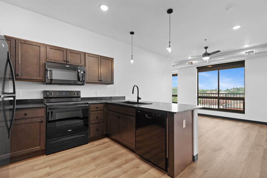 A modern kitchen with dark wood cabinets and stainless steel appliances.