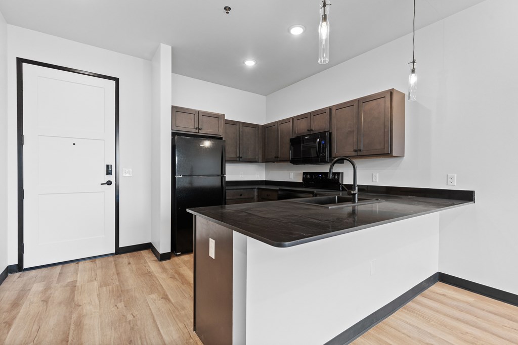 A kitchen with a black countertop and white walls.