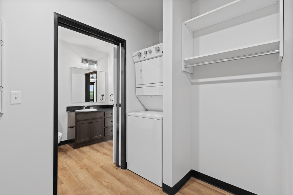A white kitchen with a refrigerator, oven, and sink.