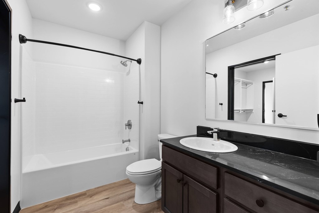 A white toilet sits in a bathroom next to a sink.