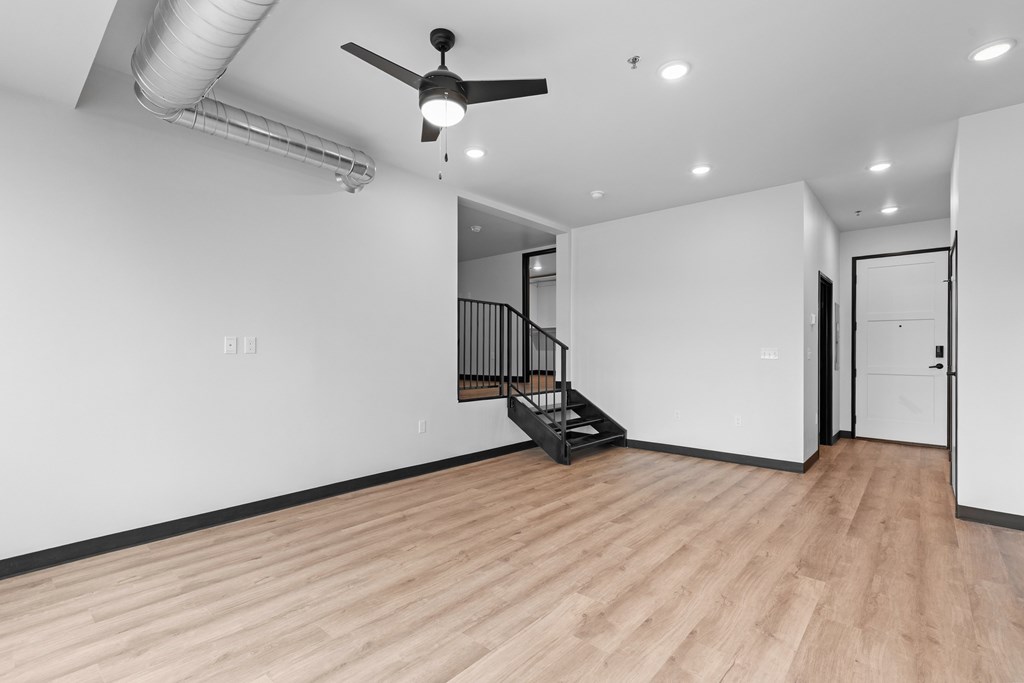 A room with a wooden floor and a ceiling fan.