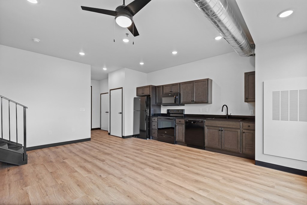 A kitchen with a refrigerator, sink, and cabinets.