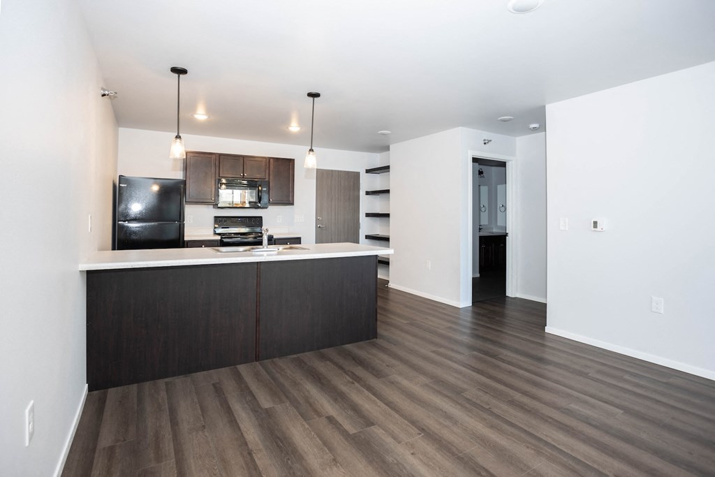 a kitchen and living room with wood floors and white walls