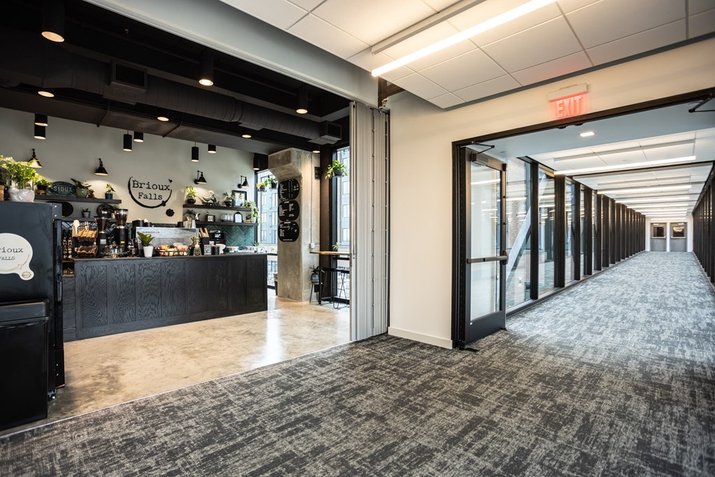 the lobby of a restaurant with a bar and glass doors