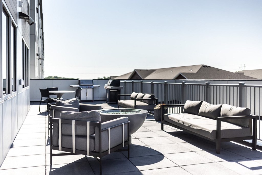 a roof deck with furniture and a fire pit