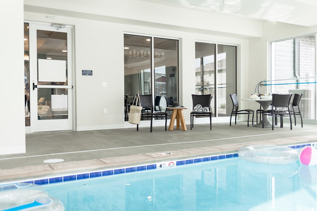 a swimming pool in front of a house with glass doors