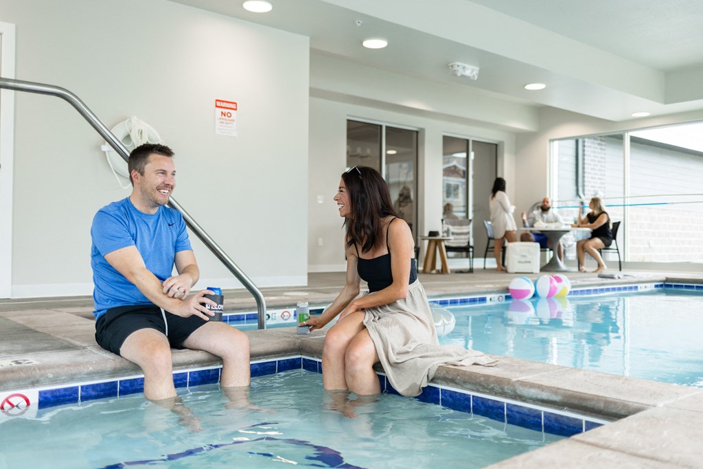 a man and a woman sitting in a swimming pool