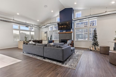 A modern living room with a grey sofa and a wooden floor.