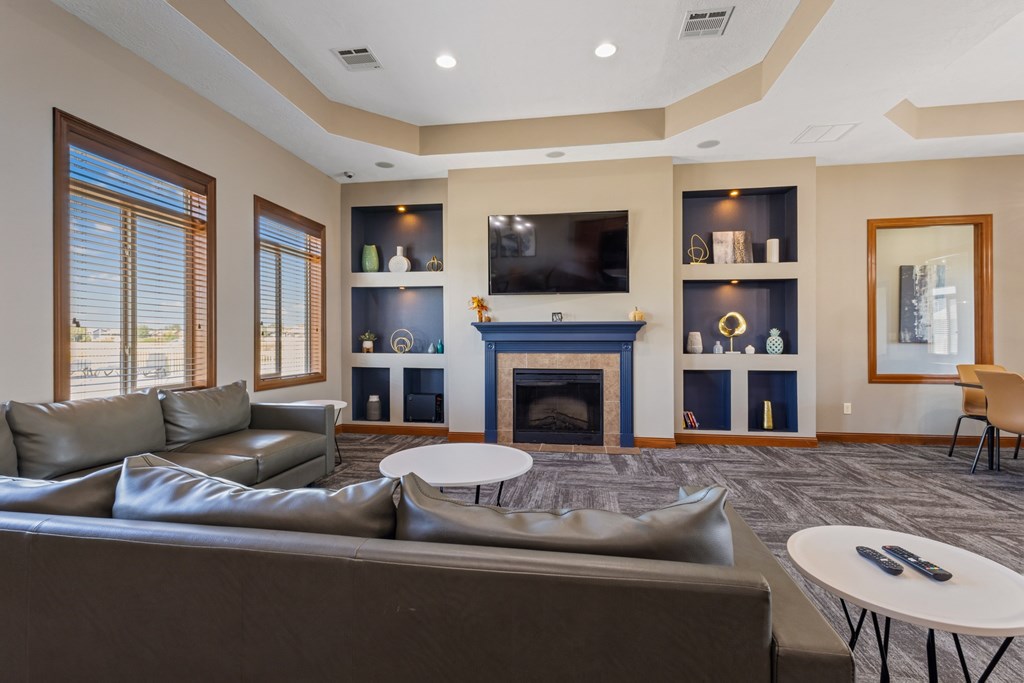 A living room with a grey couch and a fireplace.