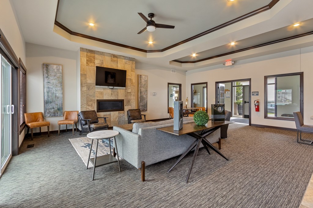 A living room with a stone fireplace and a grey sofa.