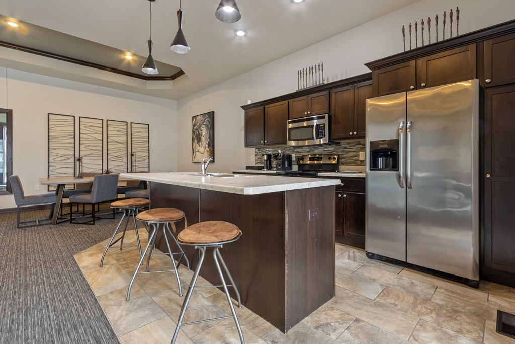A modern kitchen with a bar area and stools.