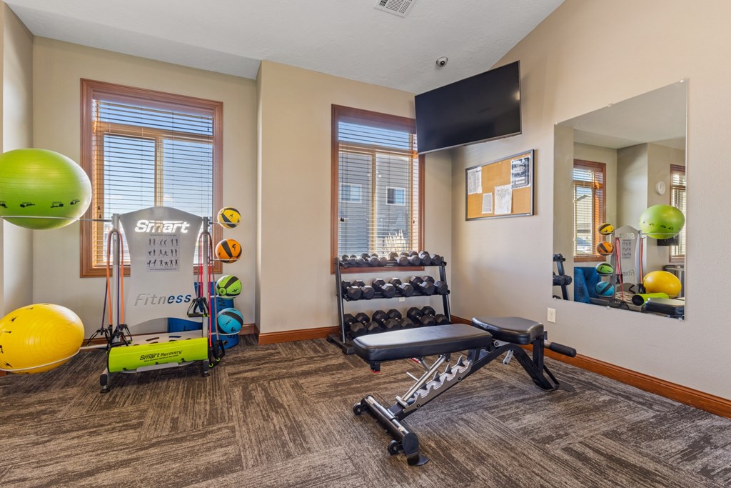 A room with a Smart Fitness sign and exercise equipment.