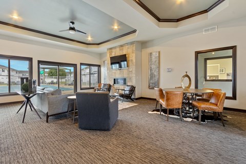 A living room with a grey carpet and brown chairs.