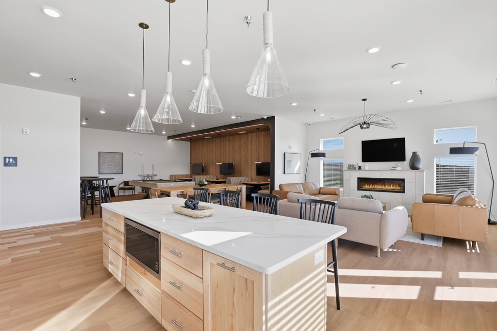 A modern kitchen with a white island and wooden floors.