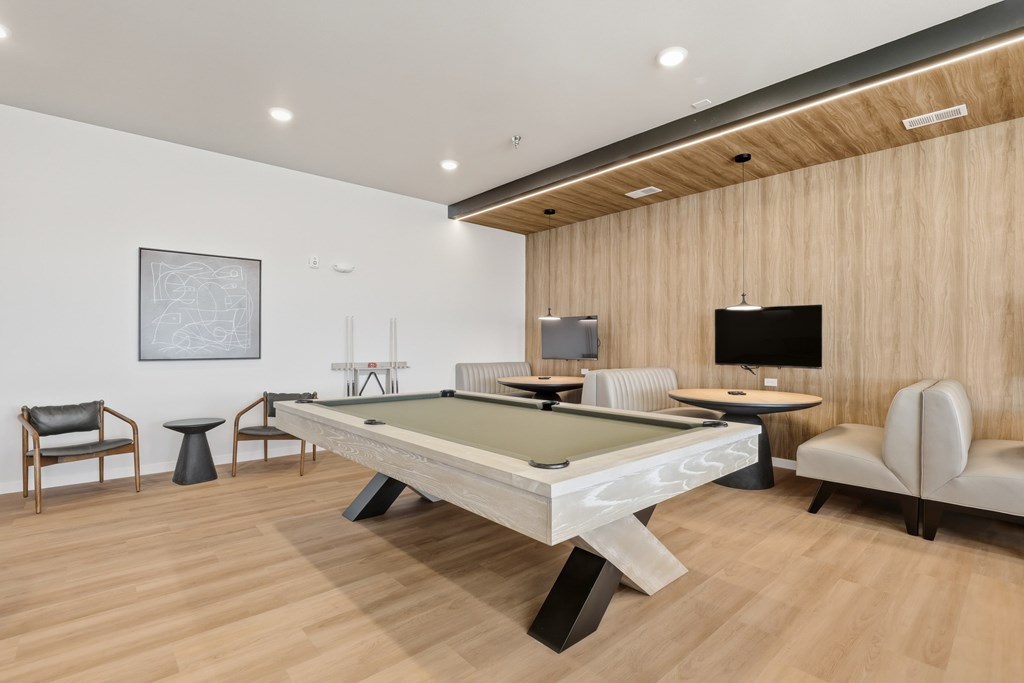 A room with a pool table and a TV.
