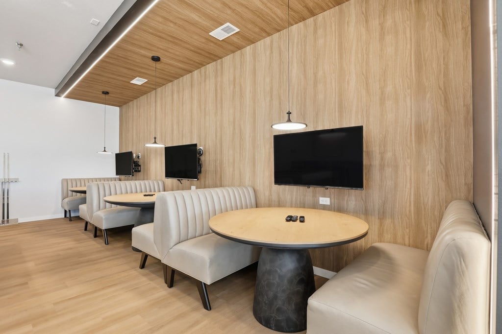 A conference room with a table, chairs and a television.