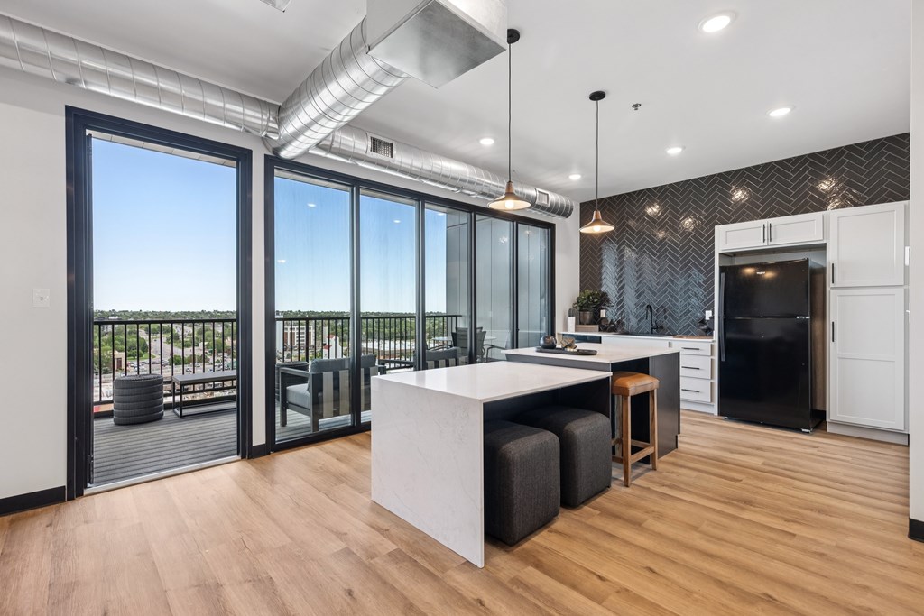 A modern kitchen with a large island and a view of the outside.