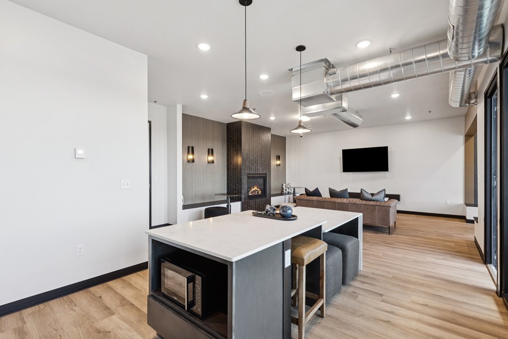 A modern kitchen with a white island and a bar stool.