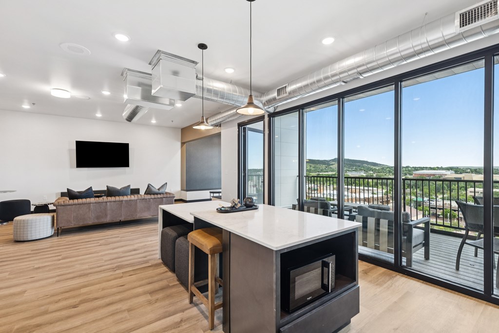 A modern kitchen with a large island and a view of the outdoors.