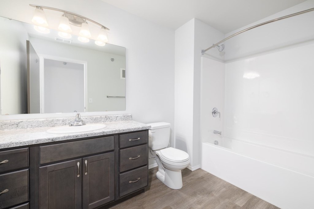 A bathroom with a white toilet and a marble counter.
