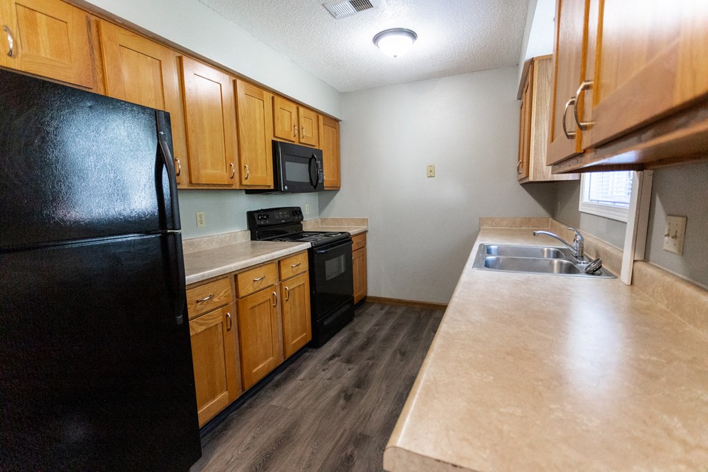 a kitchen with black appliances and wooden cabinets