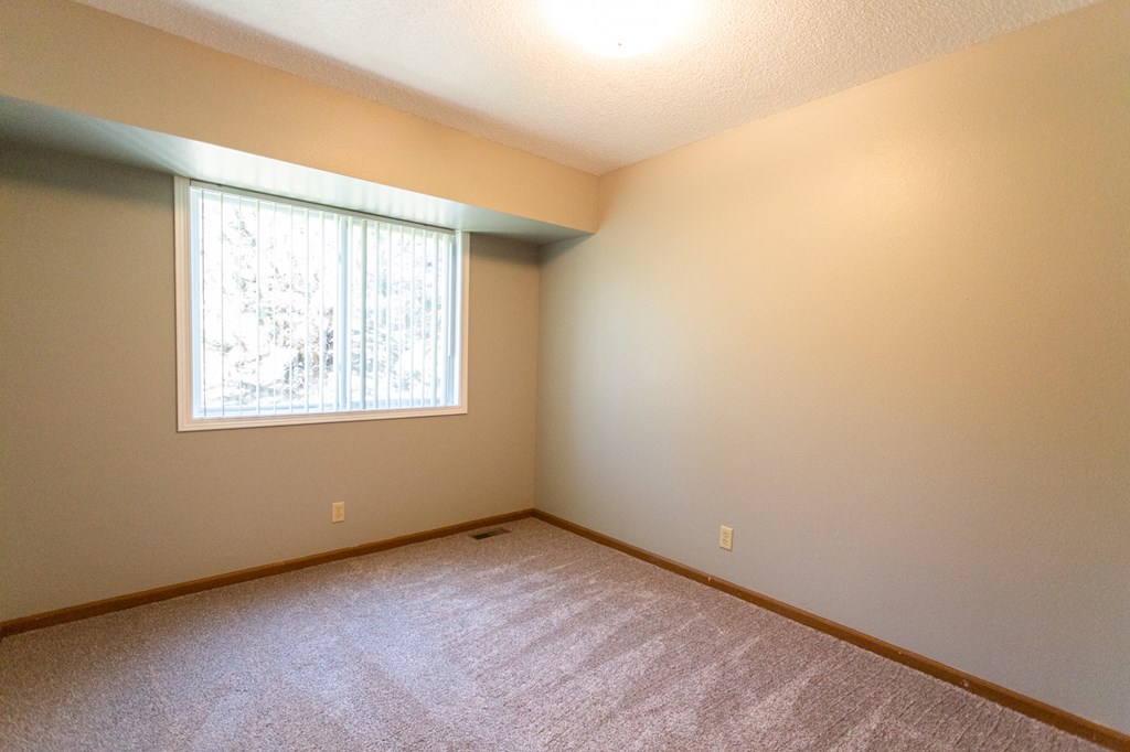 the living room of an empty home with a large window