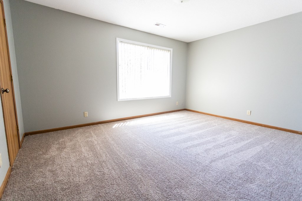 an empty room with carpet and a window