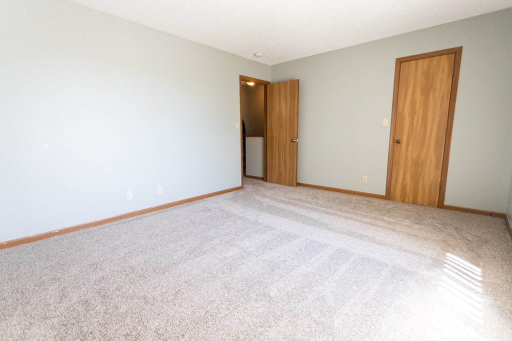 an empty living room with a door to a closet