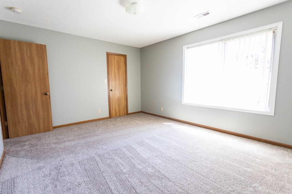 an empty room with a large window and a door