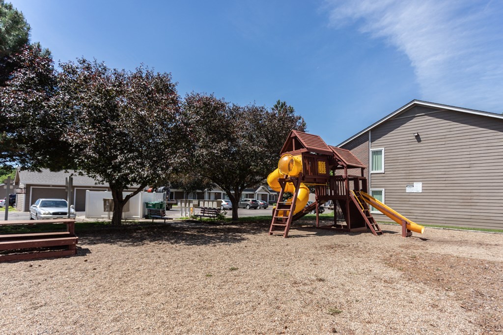 our yard has a playground with a swing set and a slide