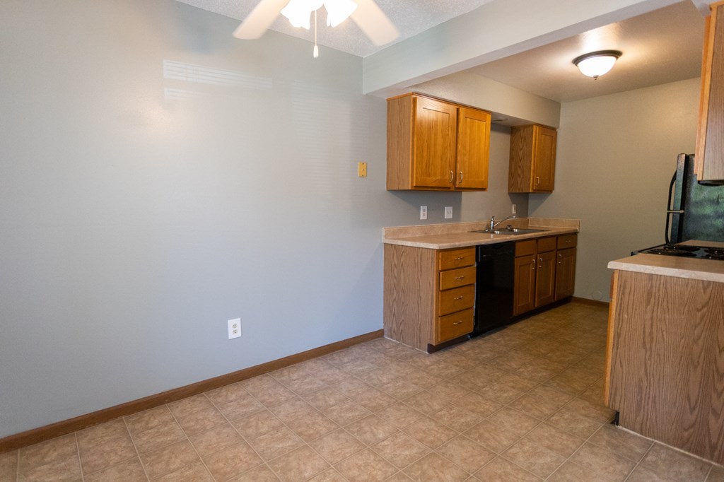 an empty kitchen with a stove and a sink