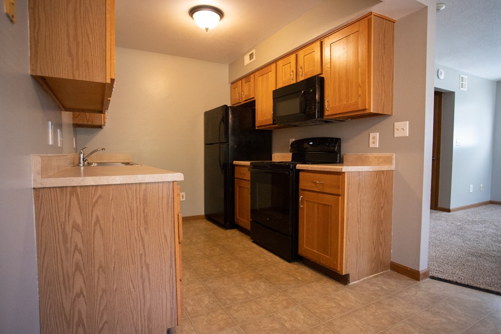 a kitchen with black appliances and wooden cabinets