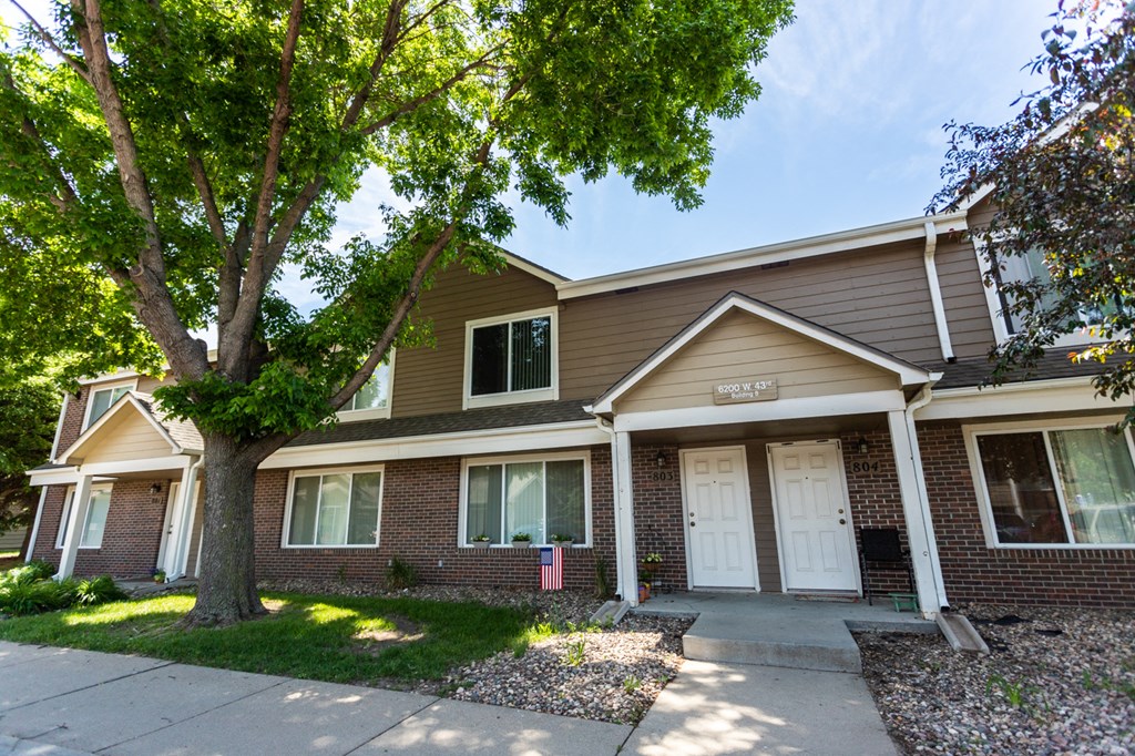 a brick house with a tree in front of it