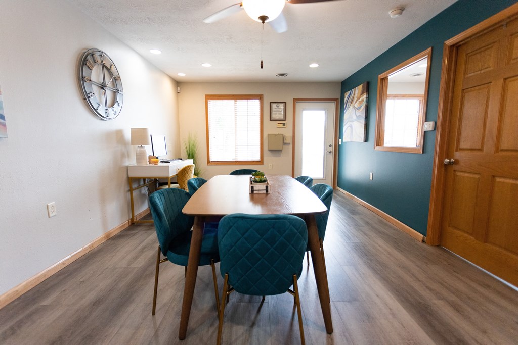 a dining room with a table and chairs and a clock on the wall