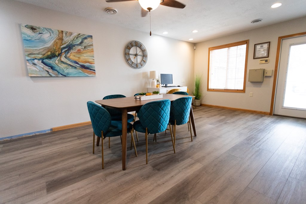 a dining room with a table and chairs and a clock on the wall